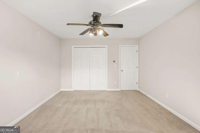 unfurnished bedroom with carpet flooring, a ceiling fan, baseboards, and a closet