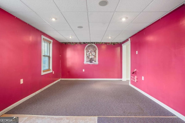 spare room featuring a paneled ceiling, baseboards, and carpet