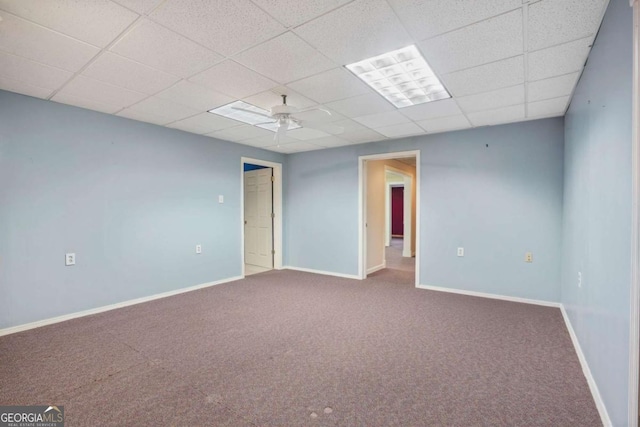 carpeted spare room featuring a paneled ceiling, baseboards, and ceiling fan