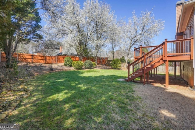 view of yard with stairway, a wooden deck, and fence