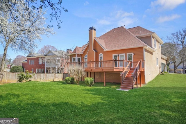 back of property featuring fence, stairway, a wooden deck, a lawn, and a chimney