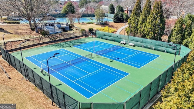 view of tennis court featuring fence