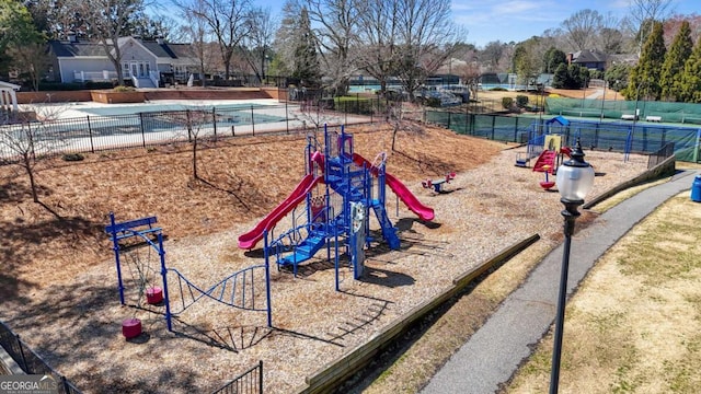 view of community featuring playground community and fence