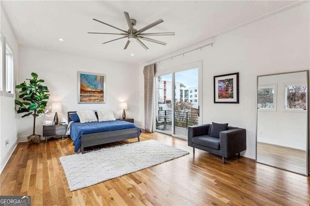 bedroom featuring baseboards, wood finished floors, access to exterior, and a ceiling fan