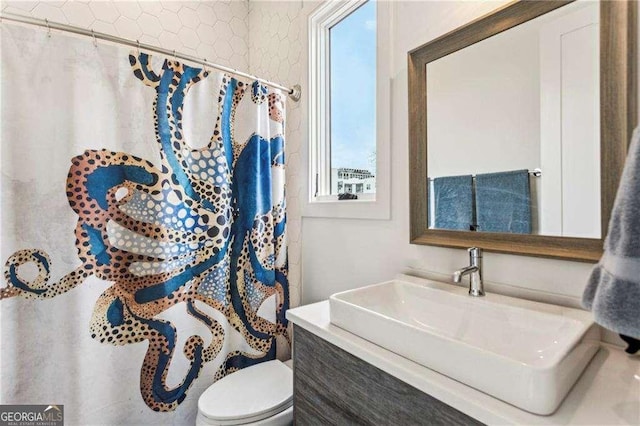 full bath featuring vanity, a shower with shower curtain, and toilet