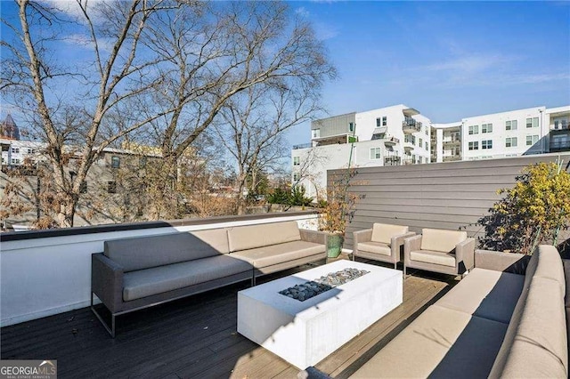 wooden terrace with an outdoor living space with a fire pit