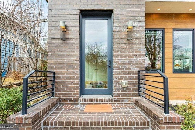 view of exterior entry featuring brick siding