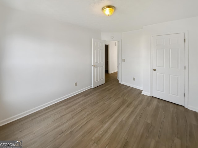 unfurnished bedroom featuring baseboards and wood finished floors