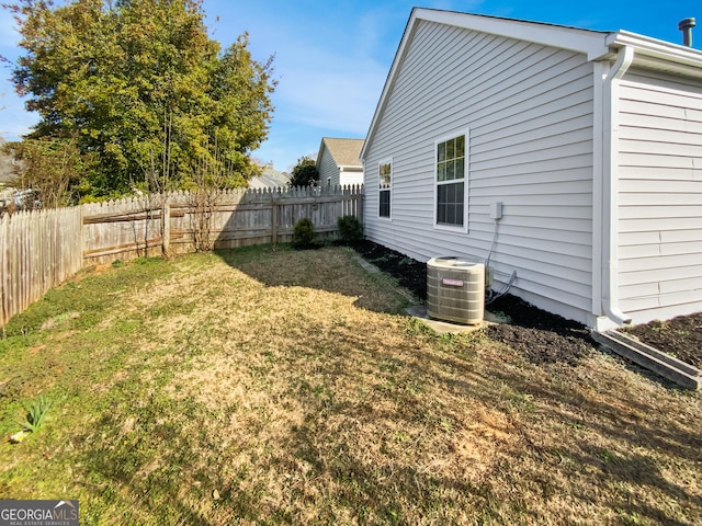 view of yard featuring central air condition unit and fence