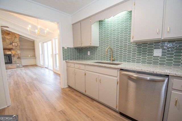 kitchen featuring light wood-style flooring, a sink, a fireplace, crown molding, and dishwasher