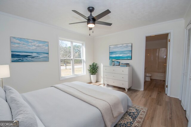 bedroom featuring ornamental molding, a ceiling fan, ensuite bath, a closet, and light wood finished floors