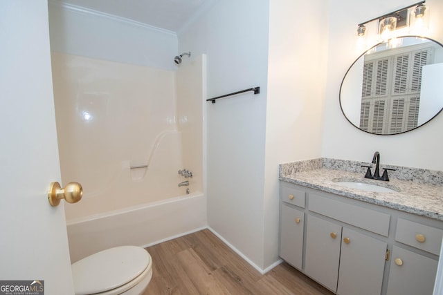 bathroom featuring vanity, wood finished floors, shower / tub combination, crown molding, and toilet