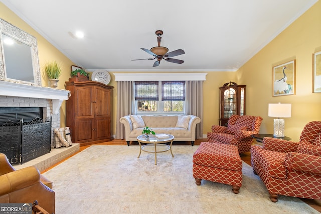 living room with crown molding, a brick fireplace, and a ceiling fan