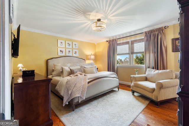 bedroom featuring crown molding, light wood-type flooring, and baseboards