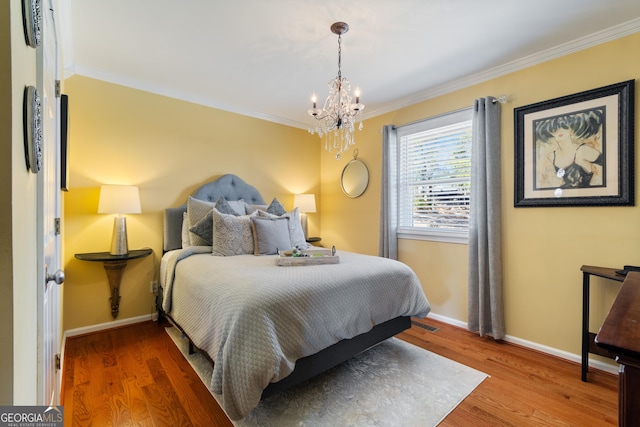 bedroom featuring wood finished floors, baseboards, a chandelier, and ornamental molding