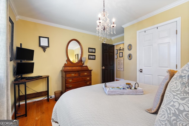 bedroom with a notable chandelier, crown molding, baseboards, and wood finished floors