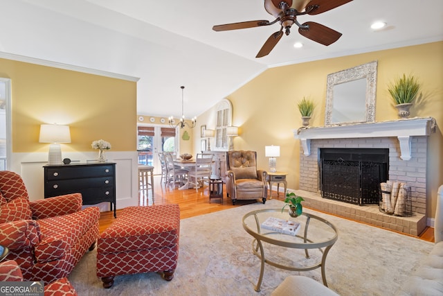 living area featuring ornamental molding, wood finished floors, recessed lighting, lofted ceiling, and a brick fireplace