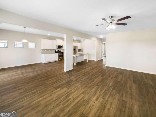 7644 Watson Cir, Locust Grove, GA 30248 - unfurnished living room featuring dark wood-style floors and a ceiling fan