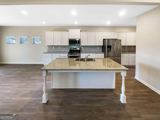 7644 Watson Cir, Locust Grove, GA 30248 - kitchen with stainless steel appliances, a kitchen breakfast bar, a kitchen island with sink, white cabinetry, and recessed lighting