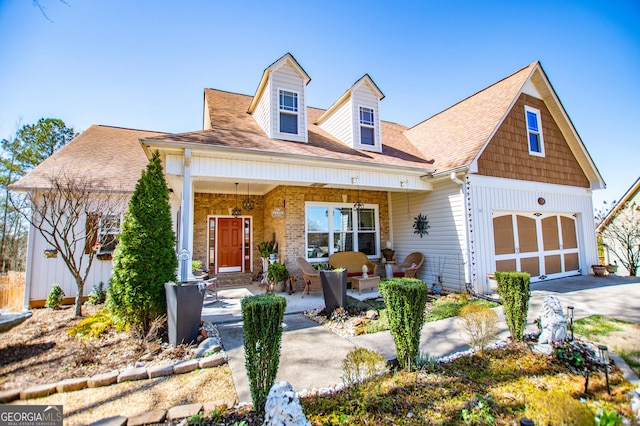 view of front of property featuring a garage, a porch, and driveway