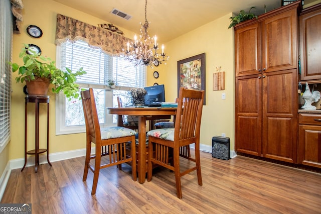 dining room featuring visible vents, baseboards, a chandelier, and light wood finished floors