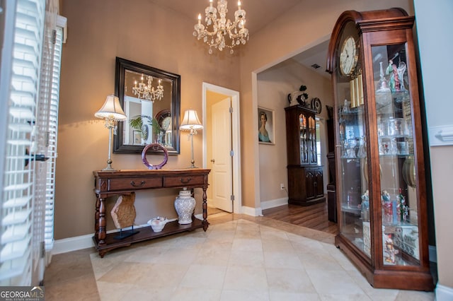 tiled entryway with a notable chandelier, visible vents, and baseboards