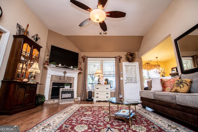 living room with visible vents, a brick fireplace, lofted ceiling, ceiling fan with notable chandelier, and wood finished floors