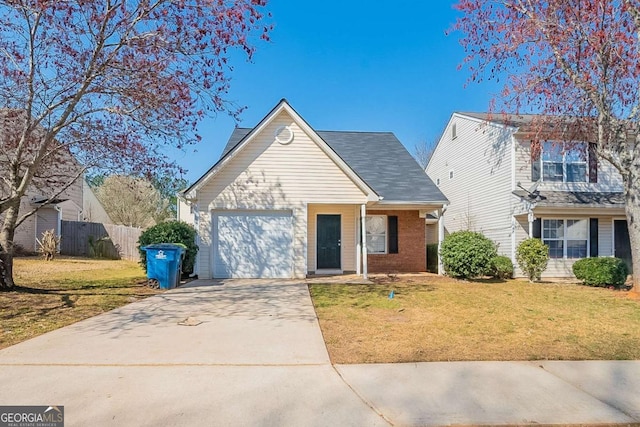 traditional home featuring a front lawn, fence, concrete driveway, a garage, and brick siding