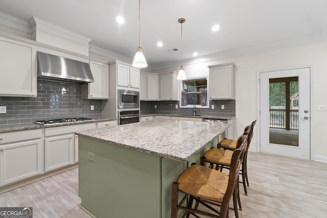 1439 Mill Pointe Ct, Lawrenceville, GA 30043 - kitchen with stainless steel appliances, wall chimney range hood, a kitchen island, decorative backsplash, and ornamental molding