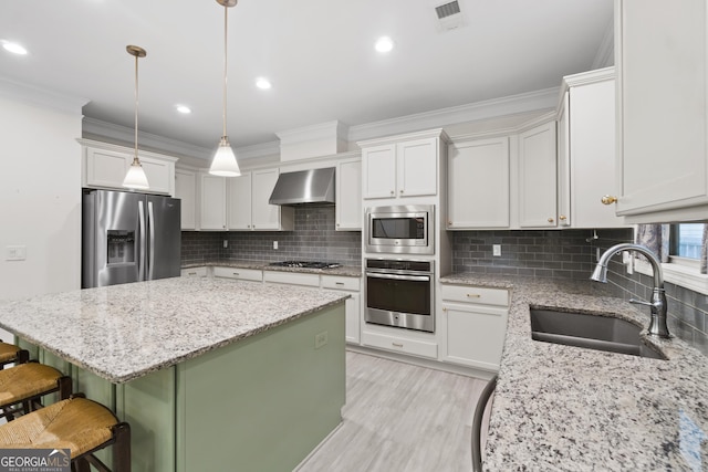 1439 Mill Pointe Ct, Lawrenceville, GA 30043 - kitchen featuring appliances with stainless steel finishes, wall chimney exhaust hood, ornamental molding, a kitchen island, and a breakfast bar area