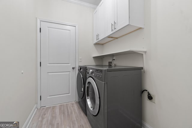 1439 Mill Pointe Ct, Lawrenceville, GA 30043 - laundry area with cabinet space, light wood-style floors, washing machine and dryer, and ornamental molding