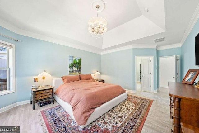 bedroom with visible vents, a raised ceiling, light wood-style floors, an inviting chandelier, and baseboards