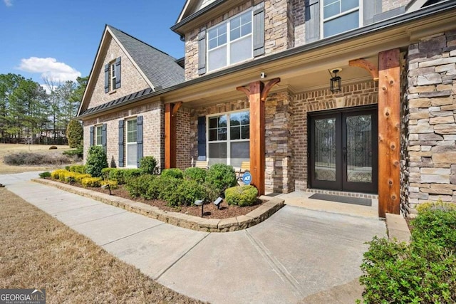 1439 Mill Pointe Ct, Lawrenceville, GA 30043 - doorway to property featuring french doors, brick siding, stone siding, and covered porch