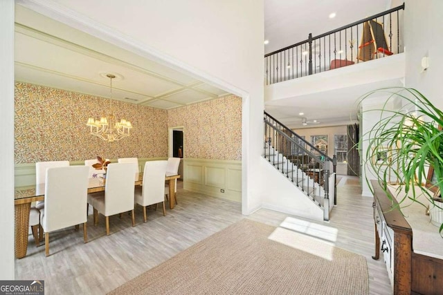 1439 Mill Pointe Ct, Lawrenceville, GA 30043 - dining space featuring a chandelier, stairway, wood finished floors, a wainscoted wall, and wallpapered walls