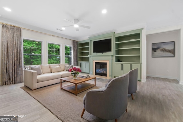 1439 Mill Pointe Ct, Lawrenceville, GA 30043 - living area featuring a glass covered fireplace, a ceiling fan, wood finished floors, recessed lighting, and ornamental molding