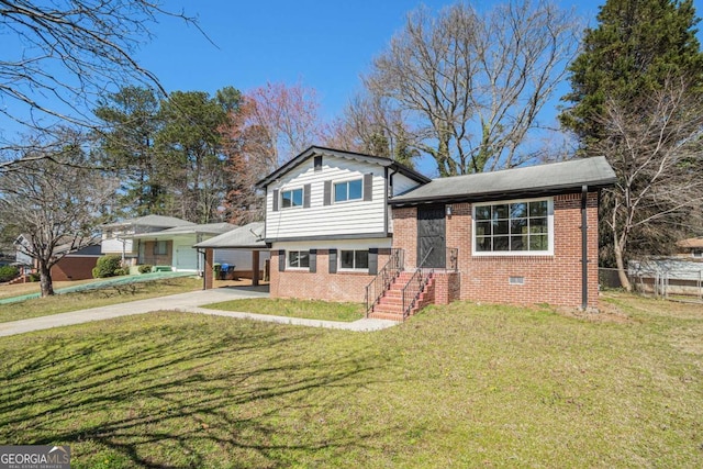 tri-level home featuring crawl space, driveway, brick siding, and a front yard