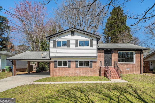 split level home with brick siding, a front yard, an attached carport, and driveway