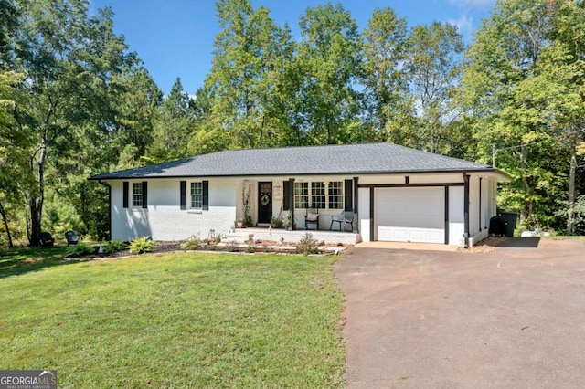 ranch-style home featuring a front yard, an attached garage, covered porch, and driveway