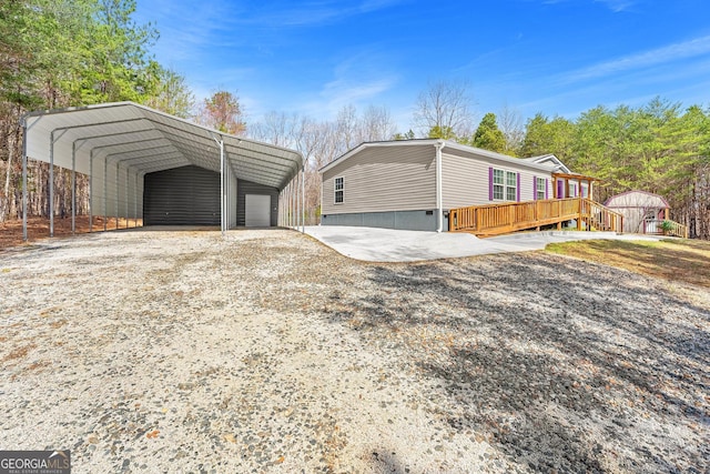 view of property exterior featuring gravel driveway, a detached carport, and an outbuilding