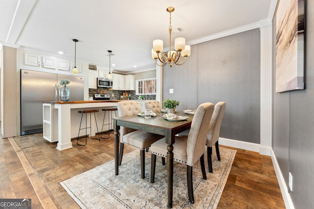 dining room featuring wood finished floors, baseboards, visible vents, crown molding, and a chandelier