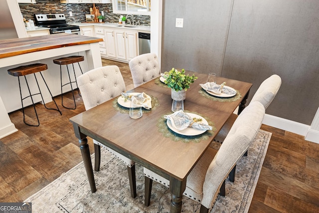 dining space featuring baseboards and dark wood finished floors