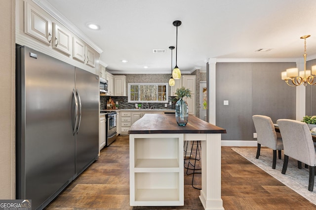 kitchen featuring visible vents, a notable chandelier, butcher block countertops, ornamental molding, and appliances with stainless steel finishes