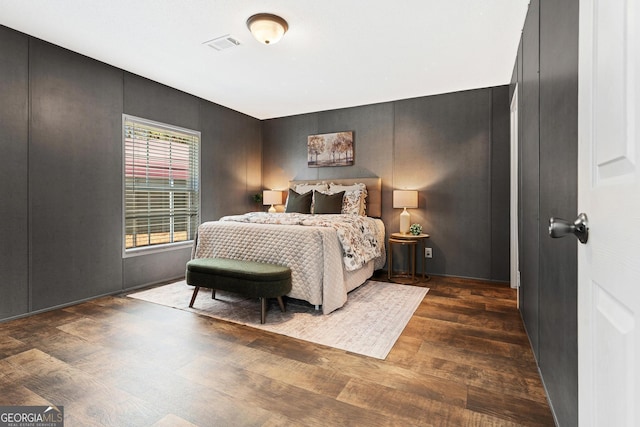 bedroom featuring wood finished floors and visible vents