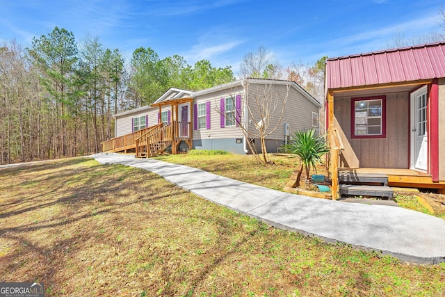 manufactured / mobile home with crawl space, metal roof, and a front yard