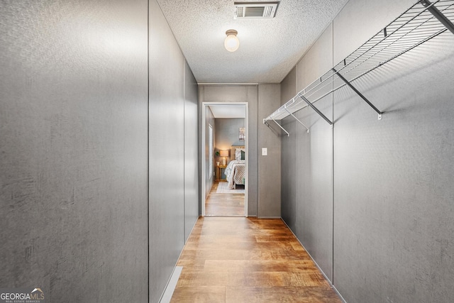 spacious closet featuring visible vents and light wood-type flooring