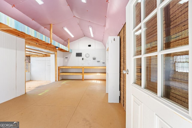 interior space featuring concrete floors and vaulted ceiling