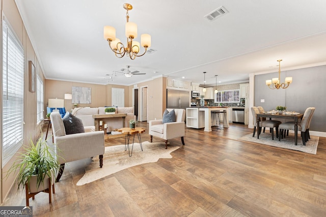 living room featuring visible vents, wood finished floors, and crown molding