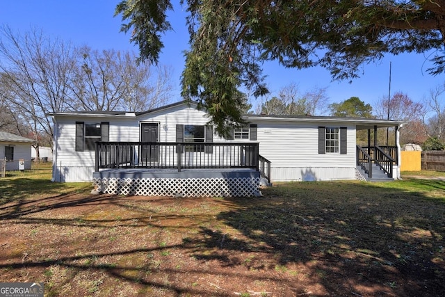 rear view of property with a lawn and a deck