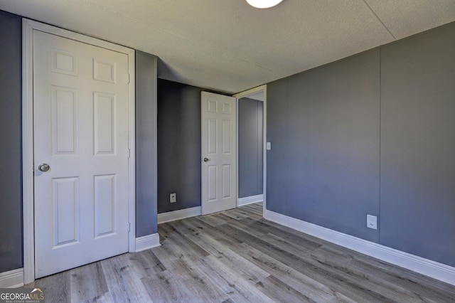 unfurnished bedroom featuring baseboards and wood finished floors