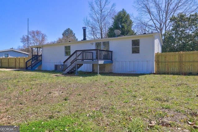 rear view of house featuring stairway, a yard, a deck, and fence